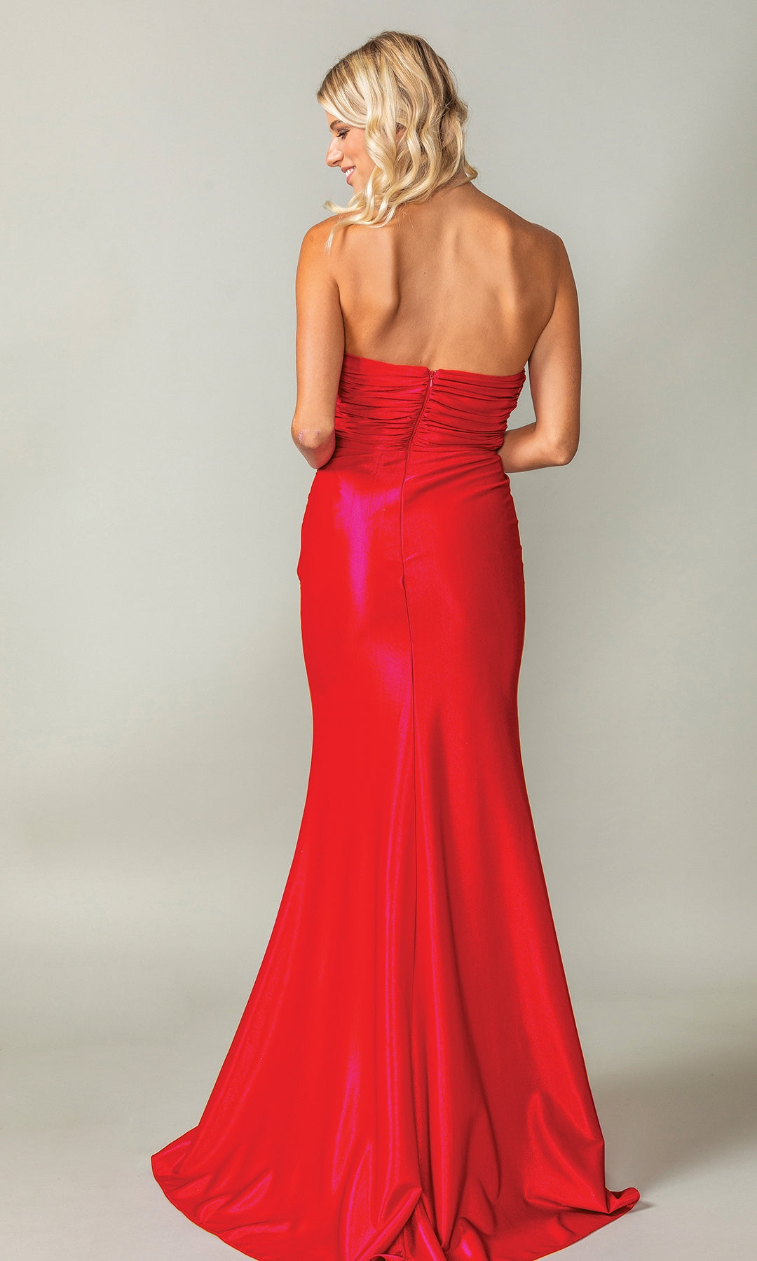 A blonde woman faces away from the camera, modeling the Strapless Long Prom Dress: Dancing Queen 4411, which features a beaded sweetheart neckline, against a plain light background.